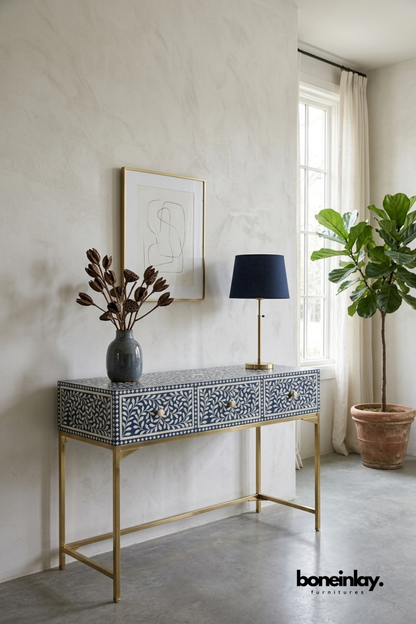 Blue floral bone inlay console table with a navy and ivory pattern.
Features three drawers for stylish, functional storage.
Handcrafted bone inlay detailing on every drawer front.
Stands on slim brass metal legs for an elegant entryway look.