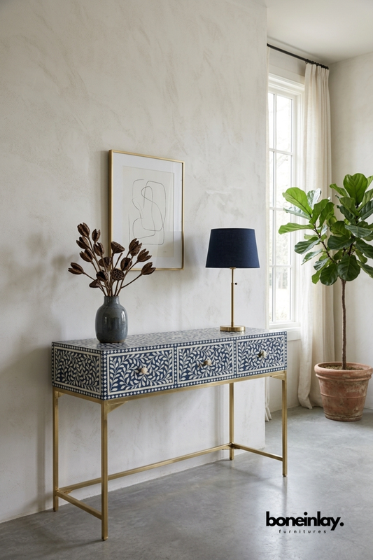 Blue floral bone inlay console table with a navy and ivory pattern.
Features three drawers for stylish, functional storage.
Handcrafted bone inlay detailing on every drawer front.
Stands on slim brass metal legs for an elegant entryway look.