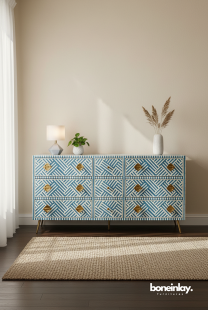 A modern sky blue and white striped bone inlay nine-drawer dresser. The piece features a high-contrast geometric pattern, bold sculptural gold-toned hardware, and minimalist metal legs. Shown in a bright, contemporary interior, this artisanal storage cabinet blends traditional Indian craftsmanship with a fresh, linear aesthetic.