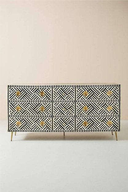 Full front view of the Optical Bone Inlay 9-Drawer Dresser in bold black and white geometric optical pattern with brass hardware and gold slim legs, shown on a clean neutral background.