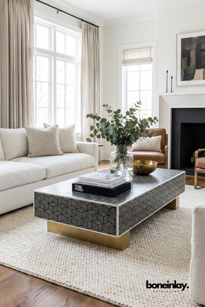 Optical Cube Monochrome Bone Inlay Coffee Table with brass legs styled in a bright modern living room with books and eucalyptus plant.