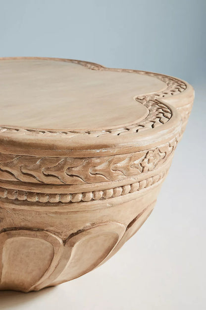Close-up of the hand-chiseled border detailing on an artisan carved solid wood accent table 