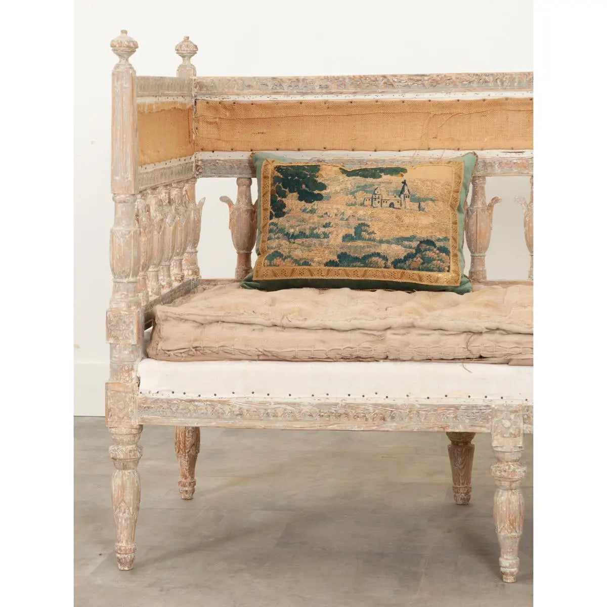Pale wood upholstered bench with a cream seat, edge detail view showing where the cushion meets the wood frame.