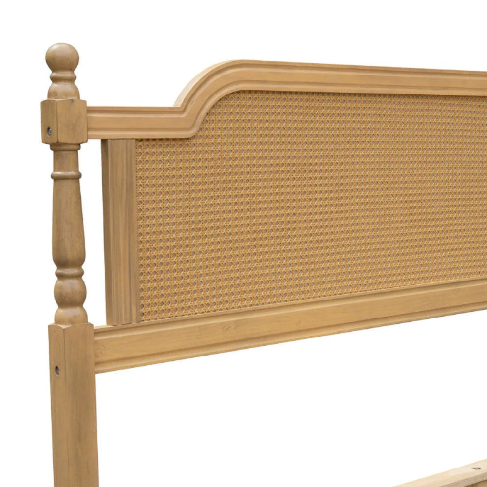 Rattan headboard bed frame, close-up of woven detail beneath the curved top rail, with a turned post at the left.
