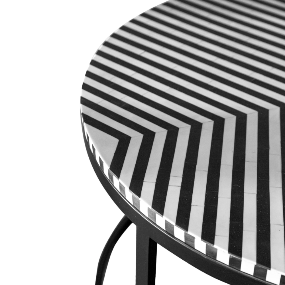 Round bone inlay coffee table with striking optical stripe pattern in black and white, handcrafted luxury artisan center table isolated on white background