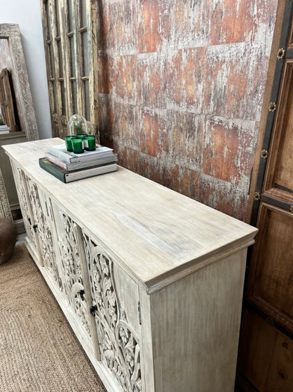 Rustic rectangular storage cabinet in wood, side profile view at an angle showing the solid end panel and carved front.