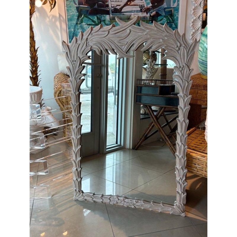 Rustic Regency wall mirror with a carved wood frame, front view beside woven seating and clear display furniture.