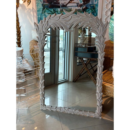 Rustic Regency wall mirror with a carved wood frame, front view beside woven seating and clear display furniture.