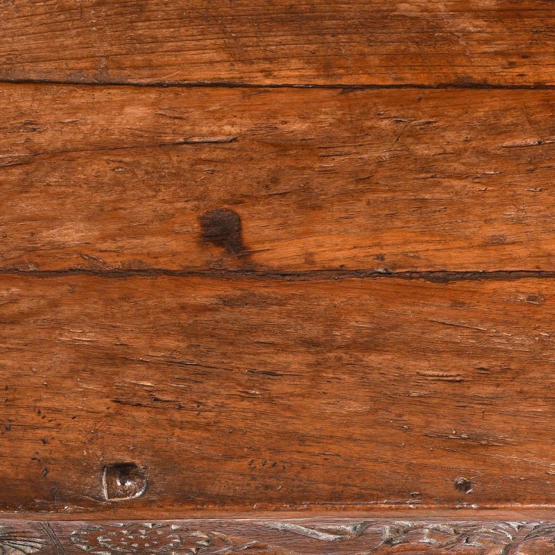 Rustic solid wood hope chest in natural walnut finish, top view close-up showing plank seams, grain and surface marks.