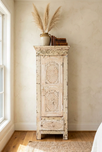 Rustic tall narrow accent cabinet with carved top, styled in living room beside a sunlit window.