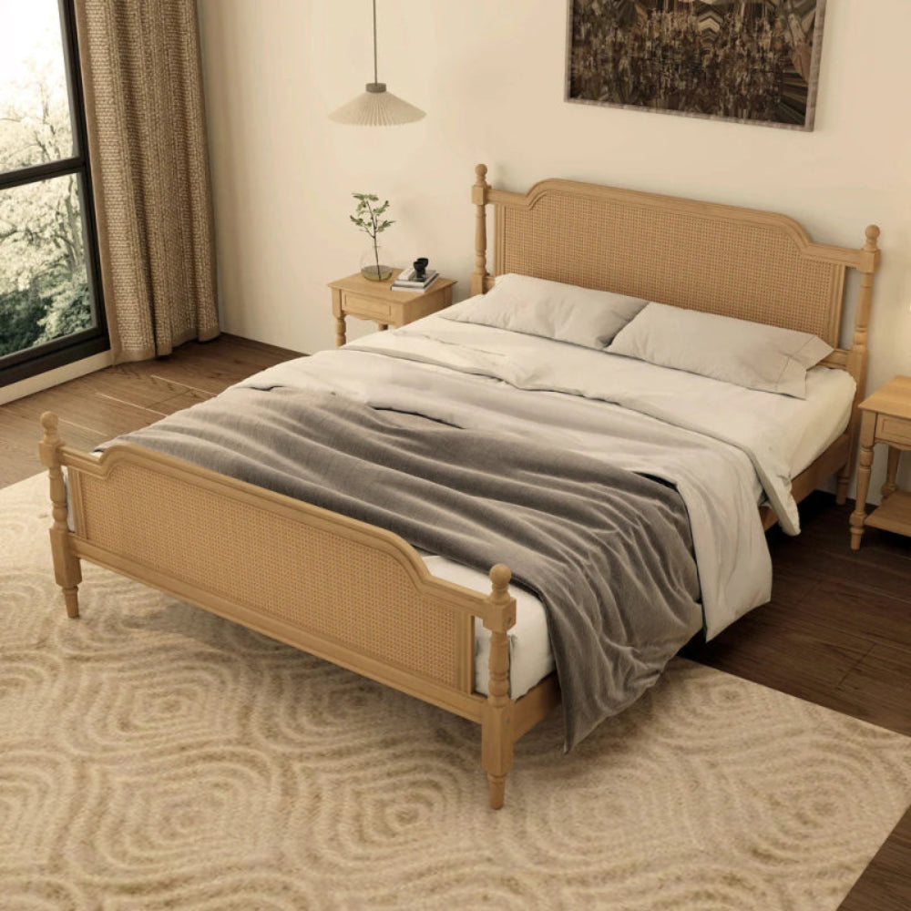 Rustic woven platform bed in natural rattan, styled in bedroom with layered bedding draped over the lower footboard.