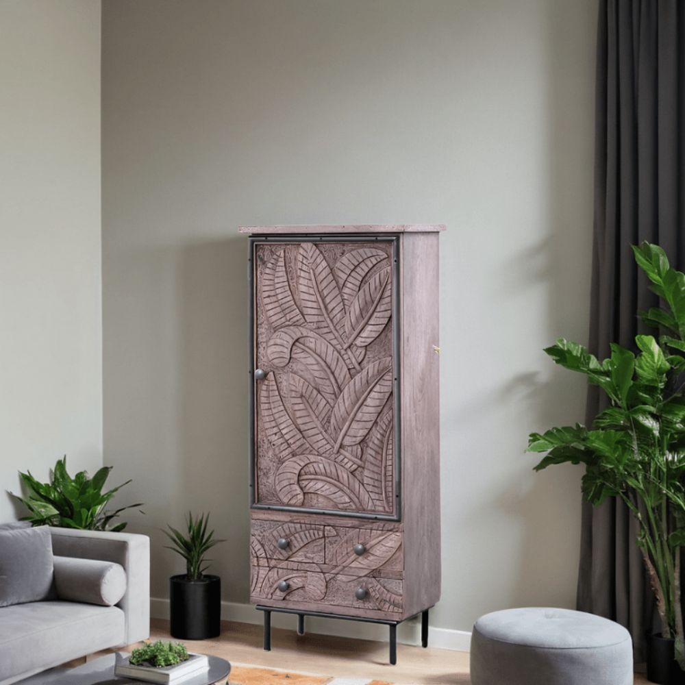 Single door armoire with a carved leaf door and black metal legs, styled in a living room beside a sofa.