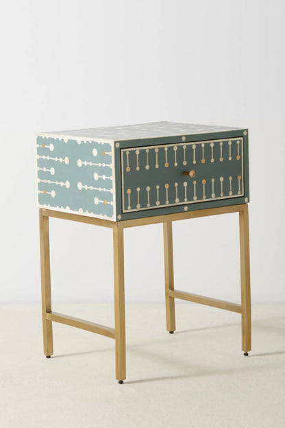 Full view of single-drawer teal bone inlay bedside cabinet with closed drawer, all-over white and gold dot-dash inlay pattern, and elegant brushed brass metal frame.
