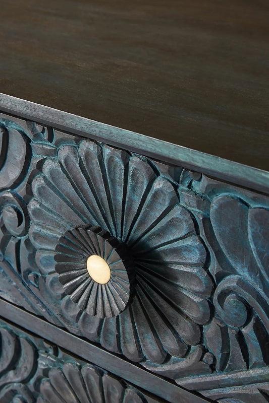 Close-up of the Gulliver wood chest of drawers, showing the recessed handle used to pull open a carved drawer.