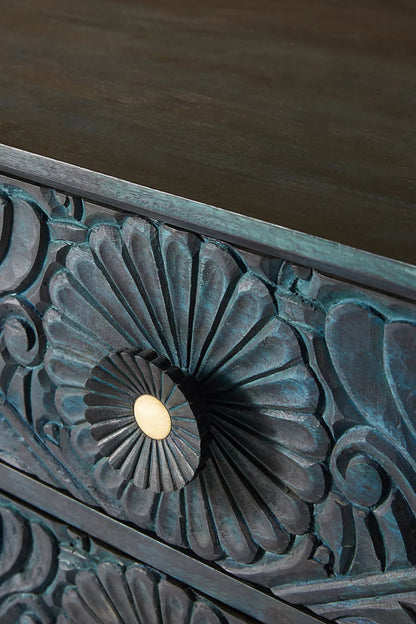 Close-up of the Gulliver wood chest of drawers, showing the recessed handle used to pull open a carved drawer.