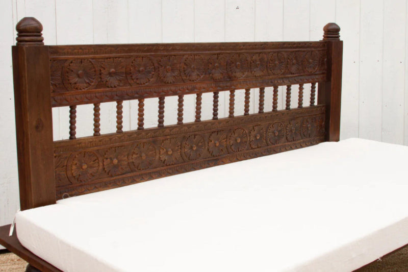 Slatted back divan in dark wood with a white cushion, shown from the front to highlight the upright backrest.