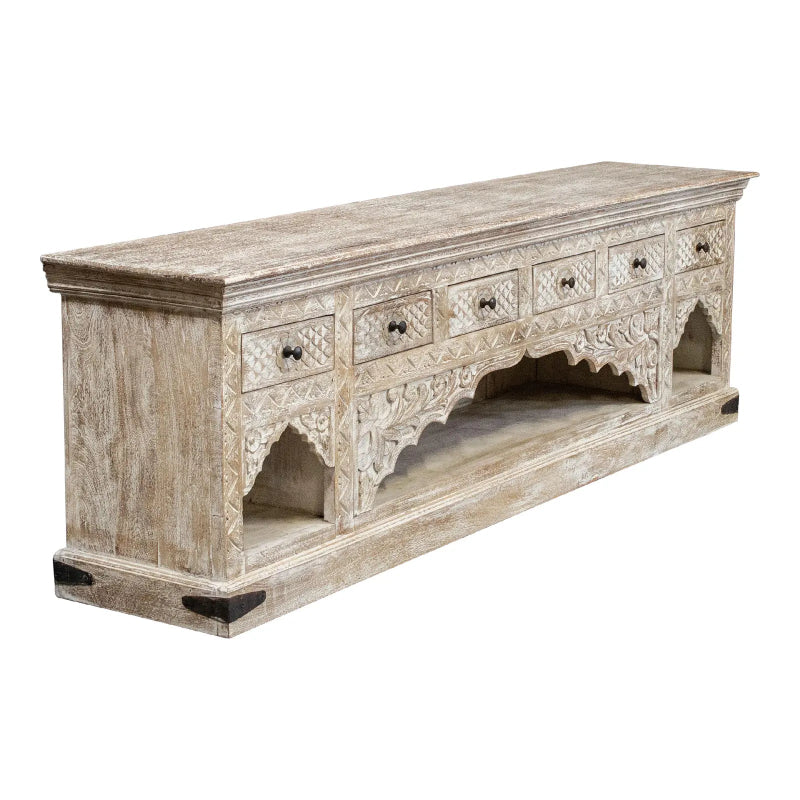 Solid wood arched buffet with a rustic finish, angled front view showing closed carved drawers and open lower shelving.