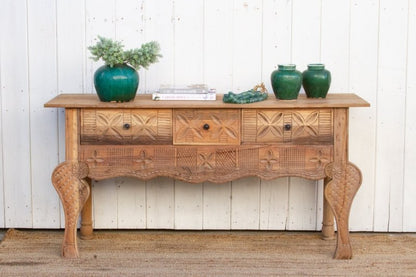 Solid Wood Sofa Table with rustic carved drawers, front view showing potted plants above a scalloped apron.