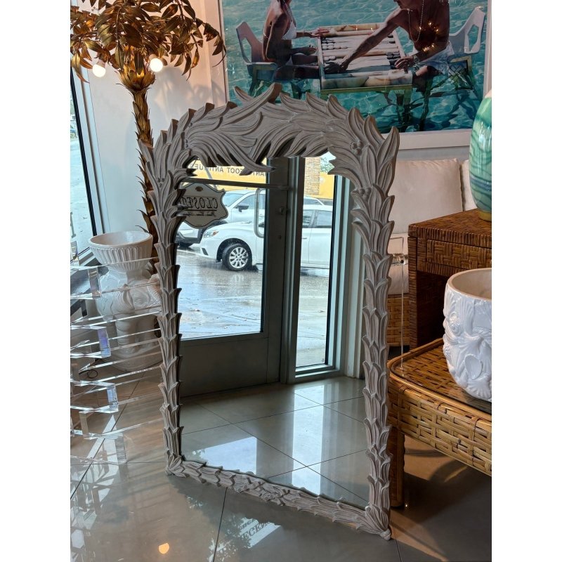Solid wood wall mirror with a rustic leafy frame, front view reflecting the glass entrance and a white car outside.