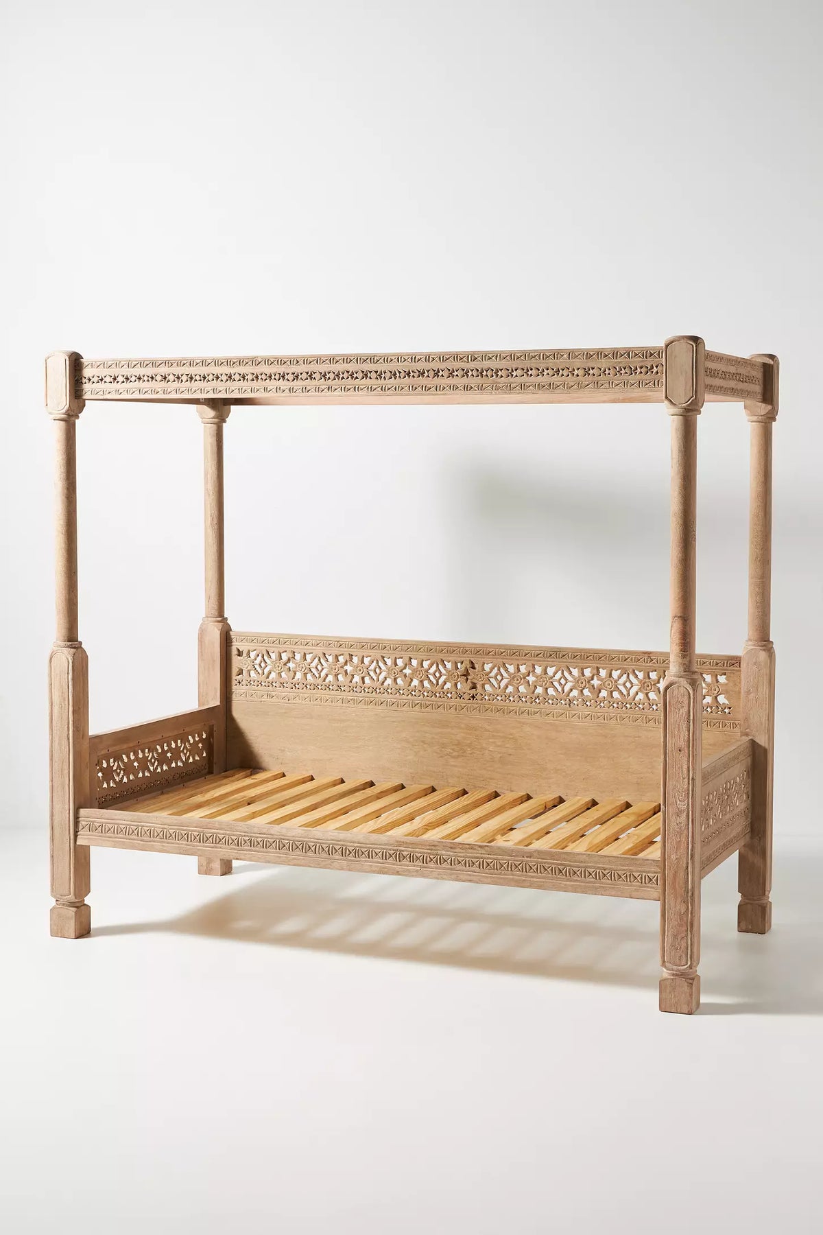 Solid wood Ezana daybed with open canopy structure and sculptural lattice side and back panels.