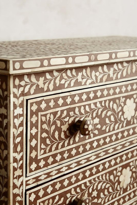 Close-up detail of spiral bone inlay pattern and round knob on handcrafted three drawer chest of drawers