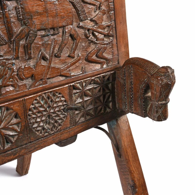Splayed leg trunk chest in natural solid wood, base detail view showing the lower corner carving and angled support.