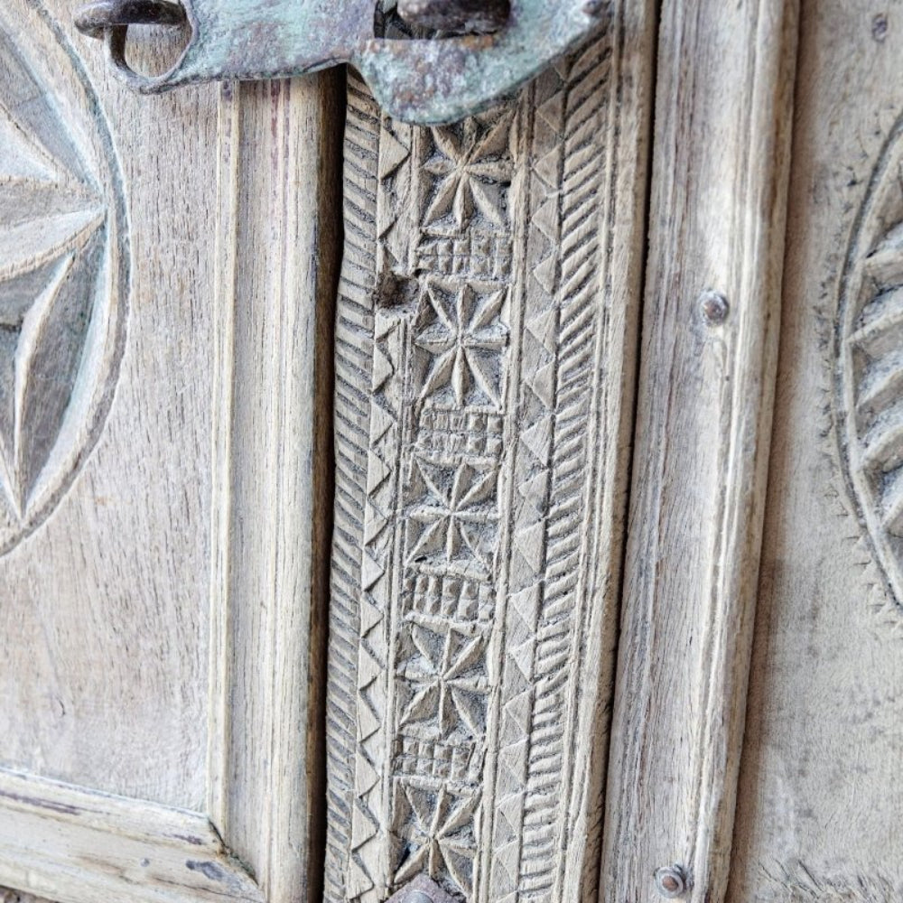 Star-carved trunk chest in pale solid wood, edge detail view showing geometric relief and diagonal carved borders.