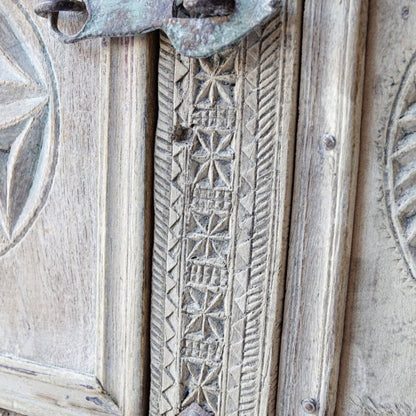 Star-carved trunk chest in pale solid wood, edge detail view showing geometric relief and diagonal carved borders.