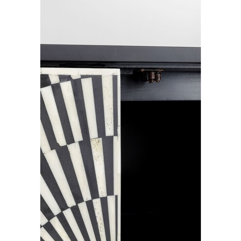 Close detail of circular gold brass handle on starburst bone inlay sideboard door, set against radiating black and ivory bone inlay pattern with open shelving behind