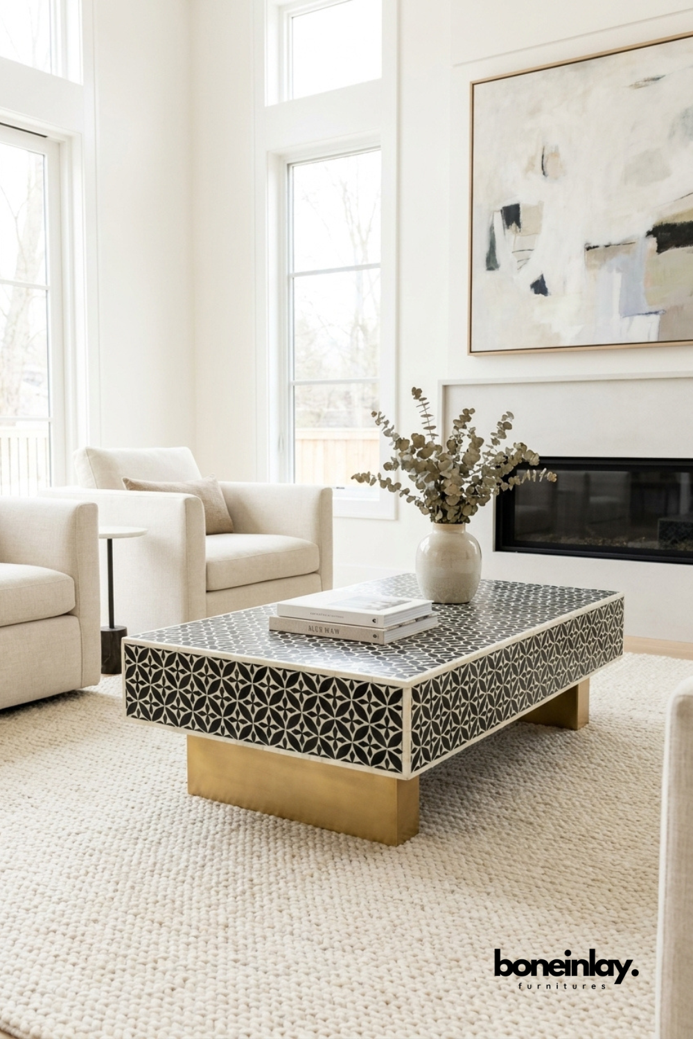 Stellar monochrome bone inlay coffee table with brass legs styled in a bright modern living room with white sofa and eucalyptus decor.