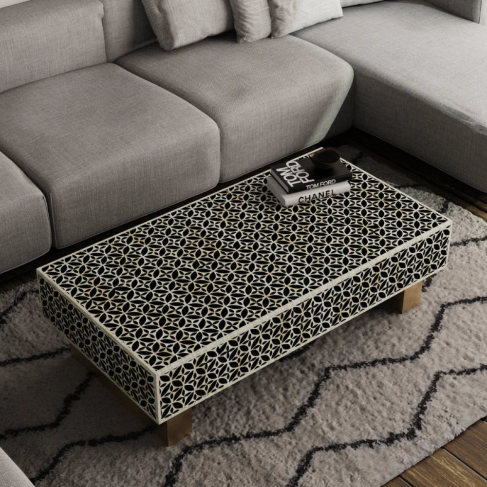 Angled view of stellar monochrome bone inlay coffee table showing intricate black and white geometric star pattern on top and side panels.