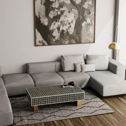 Stellar monochrome bone inlay rectangular coffee table with geometric star pattern placed in a contemporary grey sectional sofa living room.