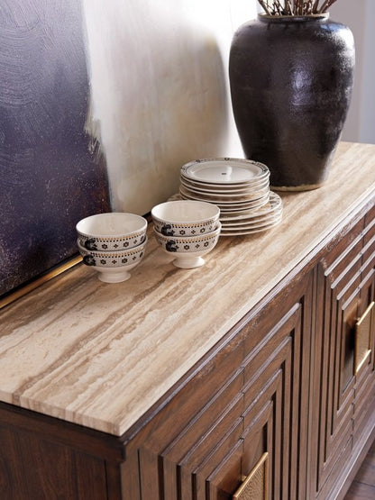 Stone-topped wood storage cabinet in walnut, edge detail view showing the veined stone overhang above carved doors.