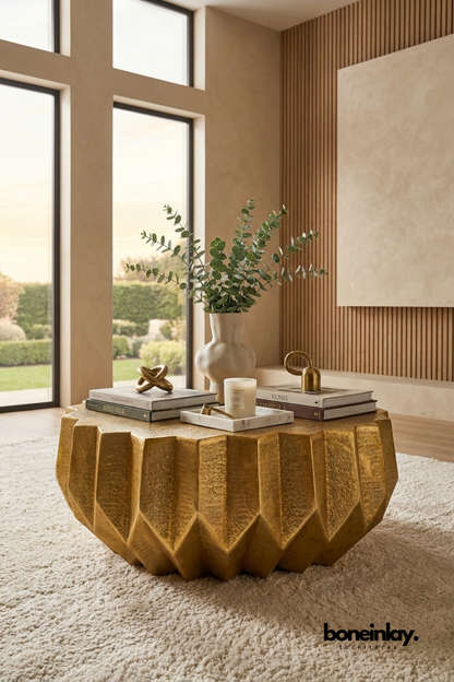 Faceted gold metal coffee table with sculptural geometric base and textured metallic finish