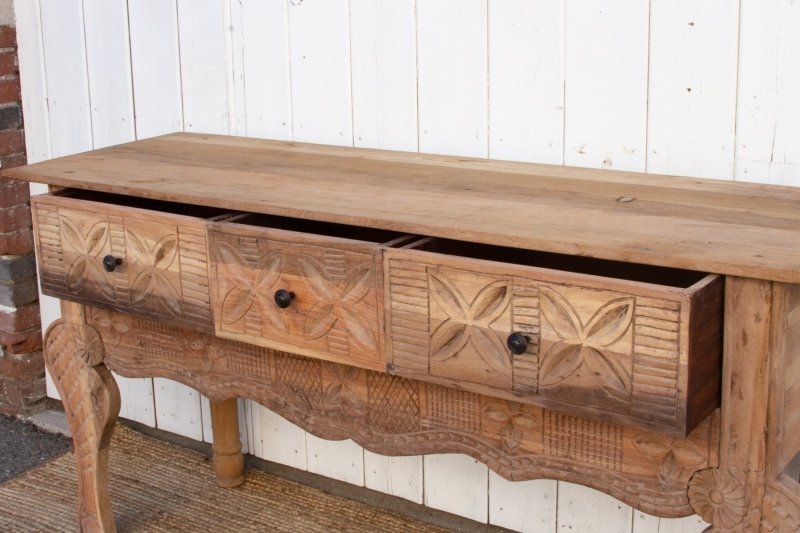Three-Drawer Wood Sofa Table in a rustic finish, open drawer view showing carved floral fronts and dark round knobs.