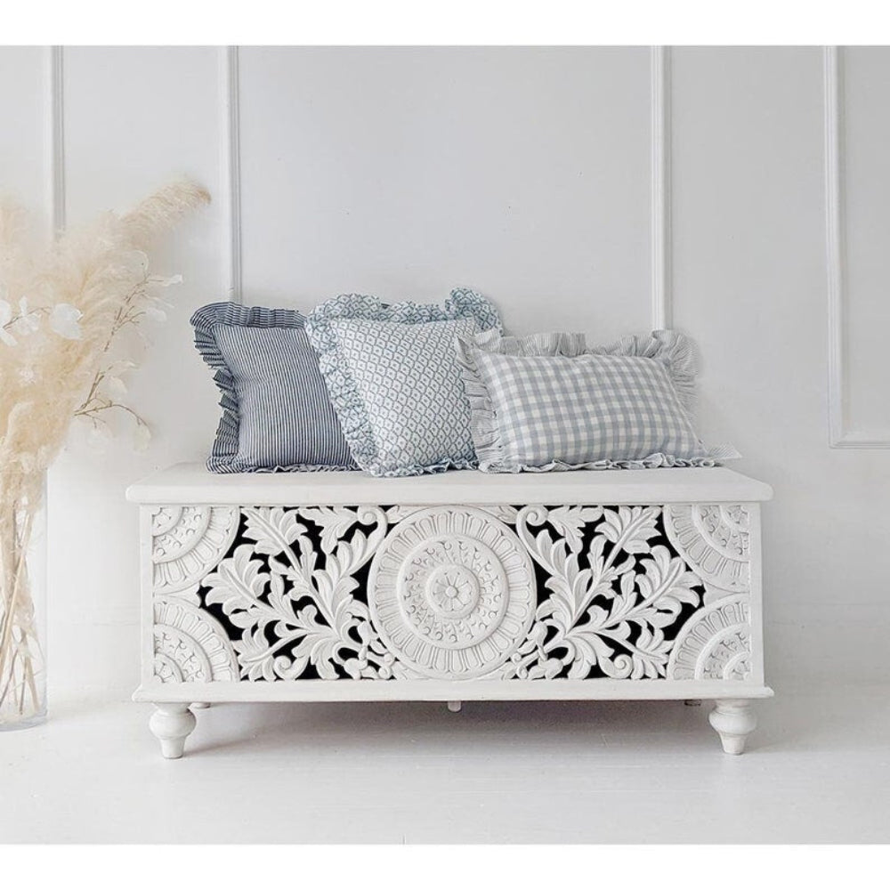 Turned Leg Blanket Box in white carved wood, front view with three patterned cushions resting on the closed flat lid.