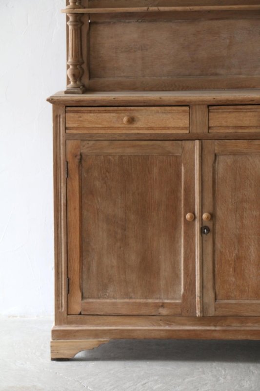 Two-door wood cupboard with framed door panels and round knobs, straight-on view of the lower cabinet.