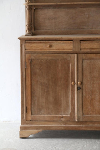 Two-door wood cupboard with framed door panels and round knobs, straight-on view of the lower cabinet.