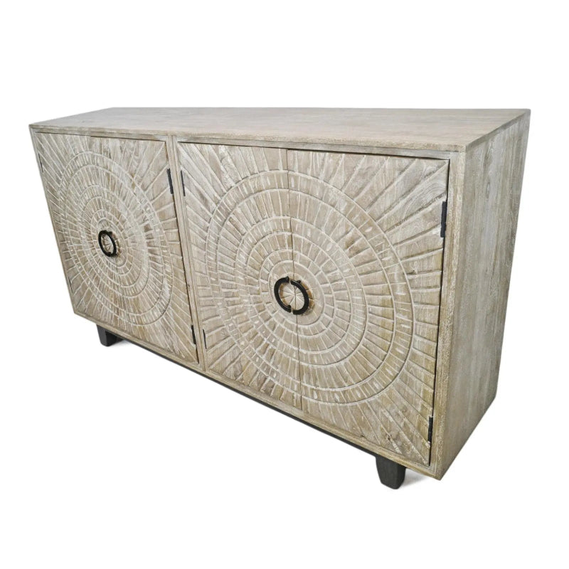 Washed medallion cabinet with carved doors and short feet, viewed from a front corner against white.