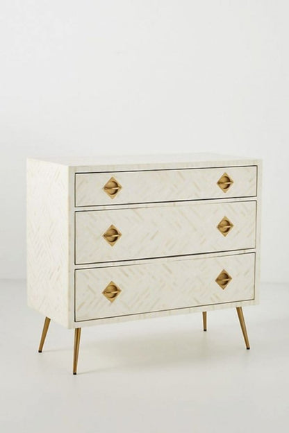 White Bone Cabinet with blue optical inlay, shown in a close front view of its three drawers and brass pulls.