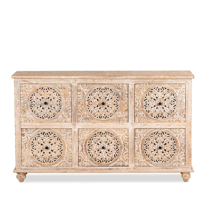 White carved chest of drawers with round medallion pulls, front view on plain background.