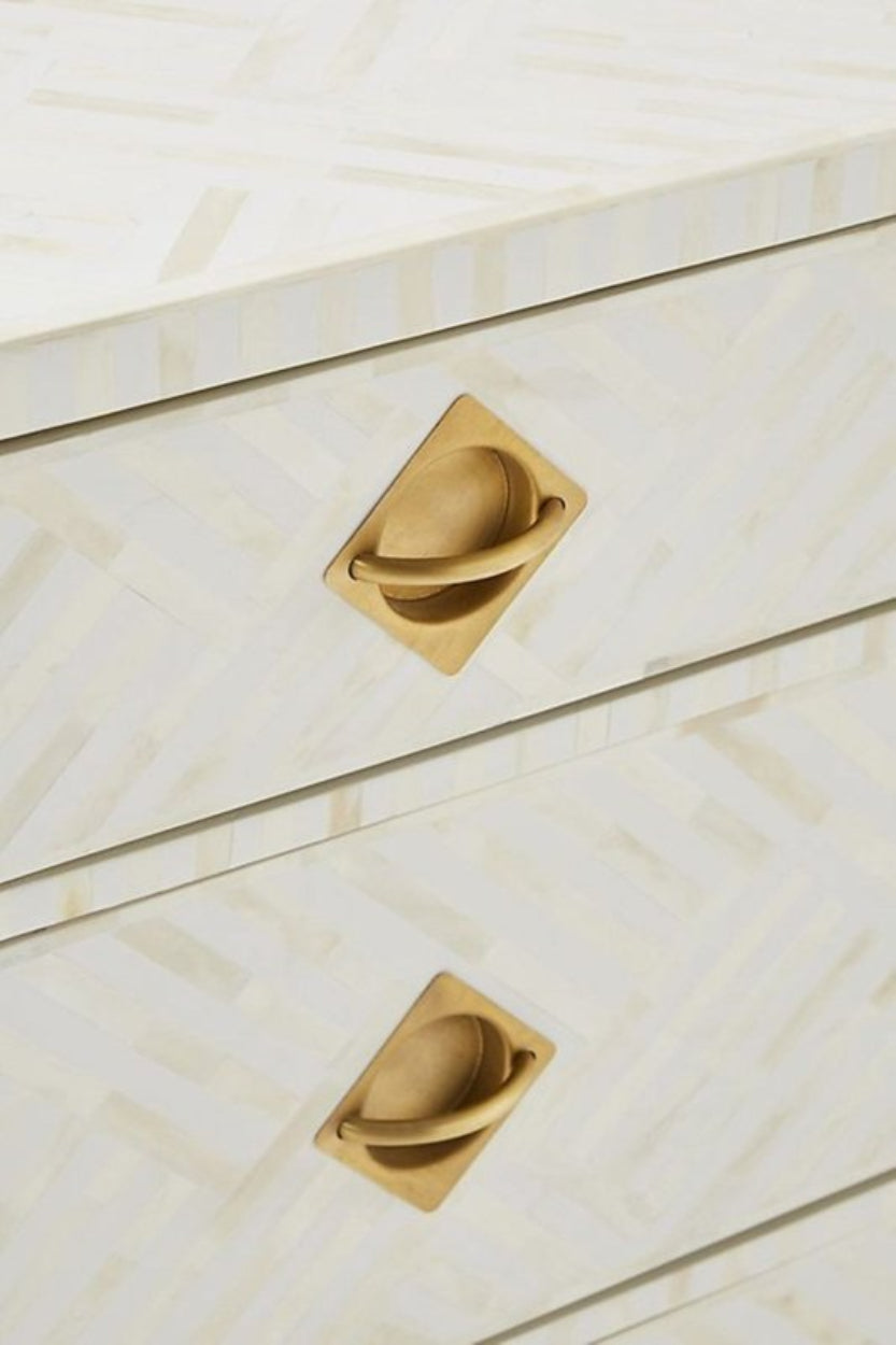 White Inlay Cabinet with bone pattern, shown in a close-up of two white drawer fronts and brass pulls.