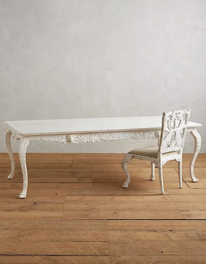The same hand-carved wooden dining table and chair set presented in a distressed white finish for a French country or shabby-chic aesthetic.