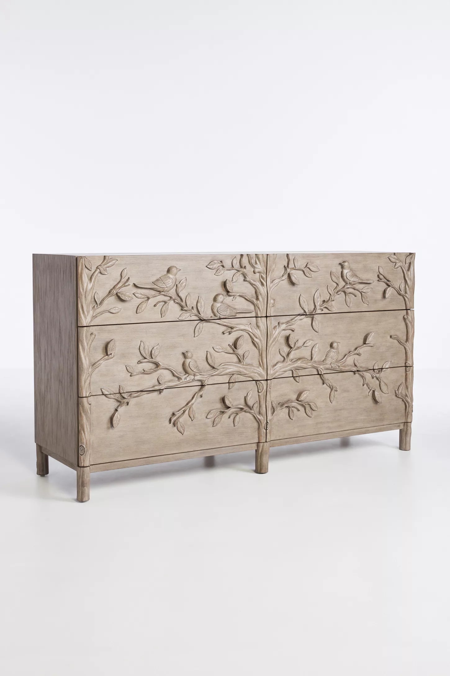 Close-up of hand-carved bird perched on branch motif on drawer front of Ornithology solid wood six drawer dresser