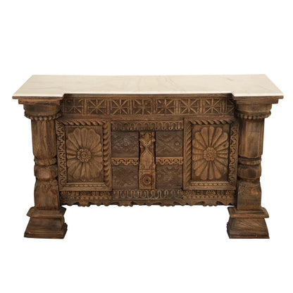 Elevated front view of an antique wooden credenza with a light-colored top, floral carvings, and geometric detailing.