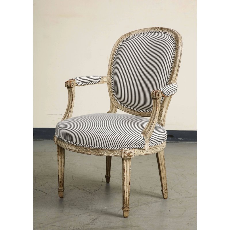 Antique-style French Provincial armchair with hand-carved wood frame, distressed white finish, and navy blue striped upholstery.