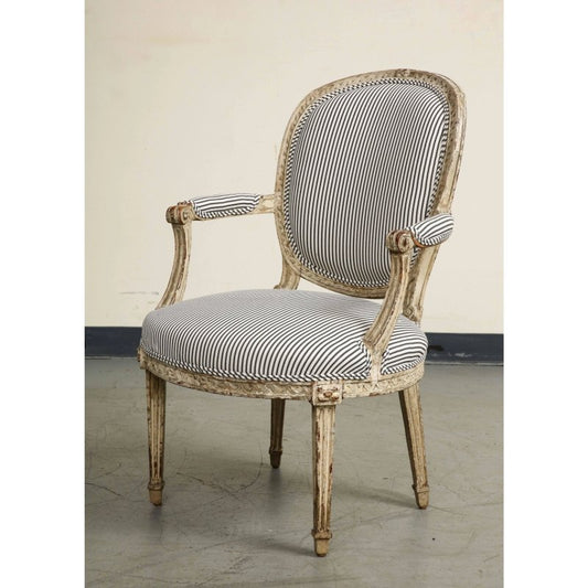 Antique-style French Provincial armchair with hand-carved wood frame, distressed white finish, and navy blue striped upholstery.