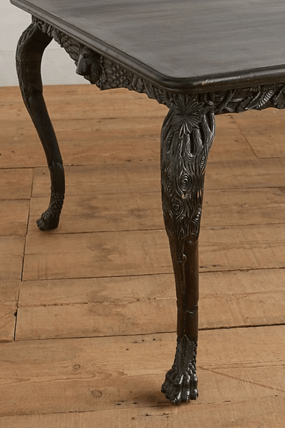 Black cabriole kitchen table in solid wood, close-up of leg showing its curved shape beneath the dark apron.