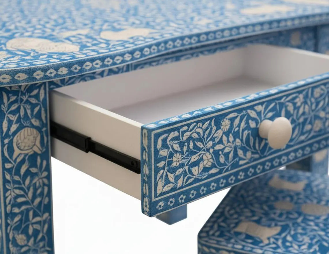  Close-up of an open drawer on a blue bone inlay kids desk, showing floral inlay and a cream-colored knob.