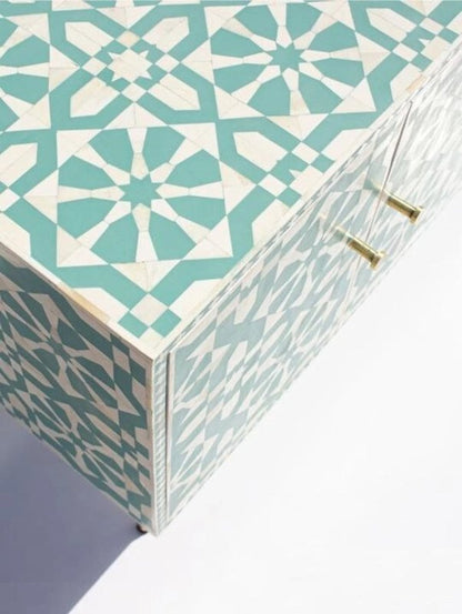 Open door detail of seafoam green bone inlay buffet cabinet revealing geometric star pattern across door panel and top surface